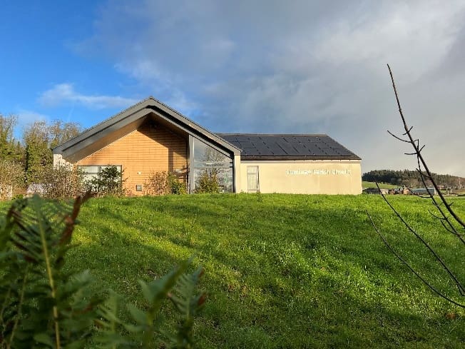 A building with a roof and grass
AI-generated content may be incorrect.